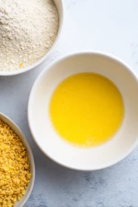 Dip chicken tenders in beaten egg, then coat with flour and finally cover in crushed cornflakes