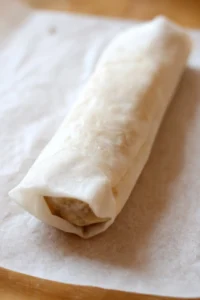 Fill egg roll wrapper with filling and roll tightly