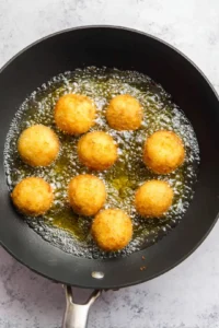 Fry the coated ice cream balls in hot oil for 10 seconds on each side