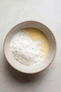 Gradually add the dry ingredients into the wet ingredients until a smooth batter forms.