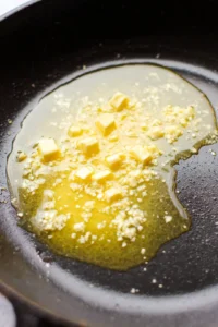 Heat a large skillet over medium-high heat and melt butter with minced garlic
