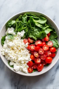 Mix cottage cheese, cherry tomatoes, and spinach in a bowl