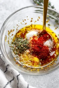 Mix olive oil, salt, pepper, paprika, garlic powder, onion powder, lemon juice, and thyme to create a marinade, then rub it on the chicken.