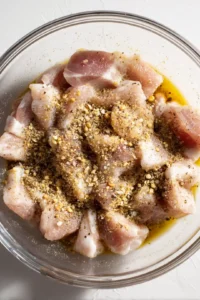 Mix pork belly pieces with salt, pepper, garlic powder, and soy sauce
