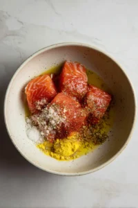 Mix the salmon fillets with olive oil, garlic powder, paprika, and salt