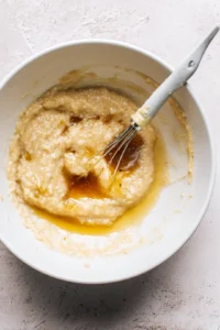 Mix together melted coconut oil, honey, vanilla extract, egg, and mashed ripe bananas until smooth