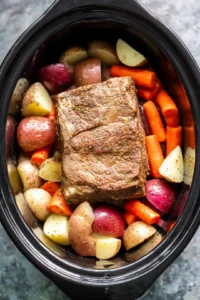 Place chopped vegetables in slow cooker and add seared roast on top