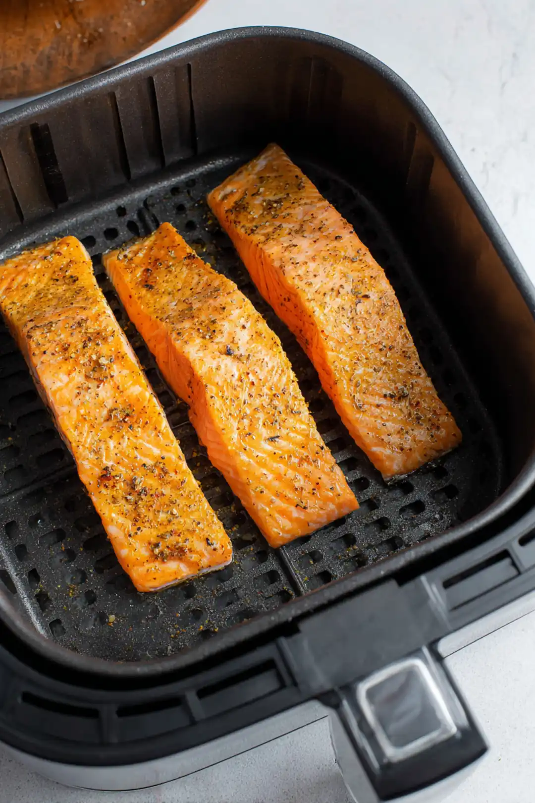 Place seasoned fillets in air fryer basket and cook for 12-15 minutes until fully cooked and flaky