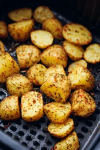 Place seasoned potatoes in air fryer basket and cook for 10 minutes, adding steak pieces for final 5 minutes
