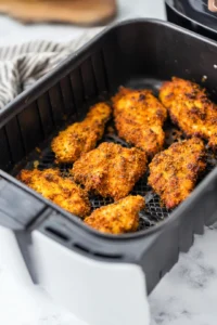 Place the coated chicken in the air fryer basket and air fry at 400°F for 10-12 minutes, shaking halfway through for even cooking.