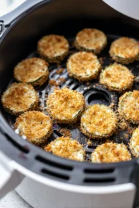 Place the coated pickle slices in the air fryer basket in a single layer and cook for about 12-15 minutes, turning halfway through, until crispy and golden brown.