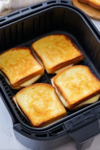 Place the sandwiches in the air fryer basket and cook at 360°F (180°C) for about 8-10 minutes until golden brown and the cheese has melted flipping halfway through if necessary.