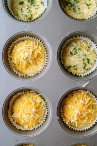 Pour the mixture into muffin cups and top with the remaining cheese
