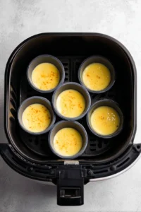 Preheat the air fryer to 275°F and pour egg mixture into molds