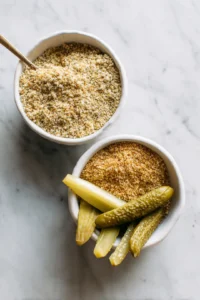 Prepare the breading by placing breadcrumbs and cornmeal in separate bowls