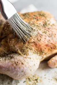 Rub the seasoning blend evenly all over the chicken, including under the skin for maximum flavor.