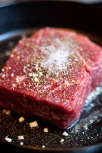 Season beef chuck roast and sear in a pan
