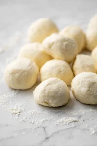 Shape small pieces of dough into rounds and place in air fryer basket with cheese and herbs