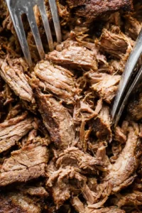 Shred the cooked beef and serve in corn tortillas with toppings