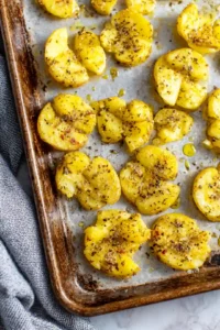 Smash potatoes and season with olive oil, salt, pepper, and Parmesan cheese before baking