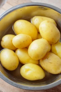Soak the cut potatoes in lukewarm water for 30 minutes to help remove excess starch, which will aid in achieving a crispier texture when cooked.