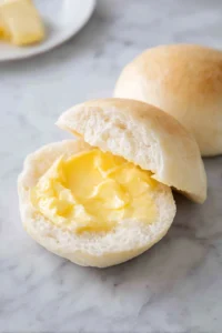 Spread melted butter on the inside of each pandesal and place your chosen filling inside.