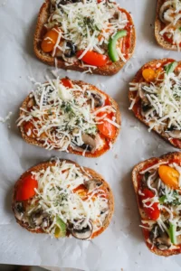 Spread pizza sauce on bread, top with mozzarella and vegetables