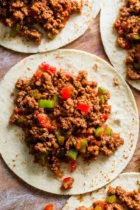Top tacos with shredded lettuce, cheddar cheese, diced tomatoes, pickles, and Big Mac sauce