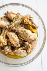 Toss chicken wings with vegetable oil, lemon pepper, salt, and black pepper until coated