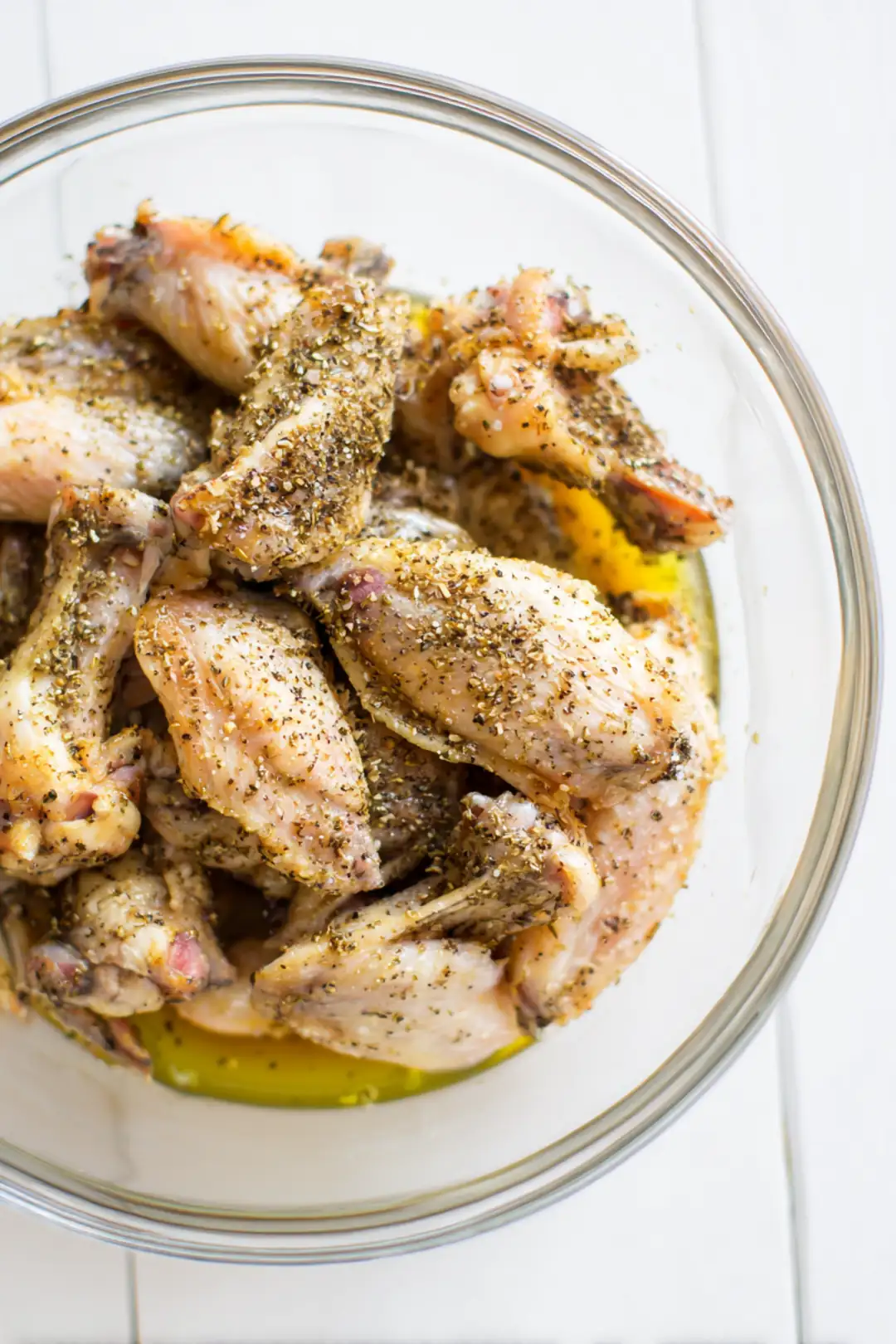 Toss chicken wings with vegetable oil, lemon pepper, salt, and black pepper until coated