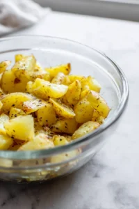 Toss potatoes with oil and spices for air frying