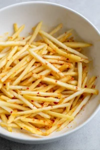 Toss the fries with vegetable oil, salt, paprika, and garlic powder