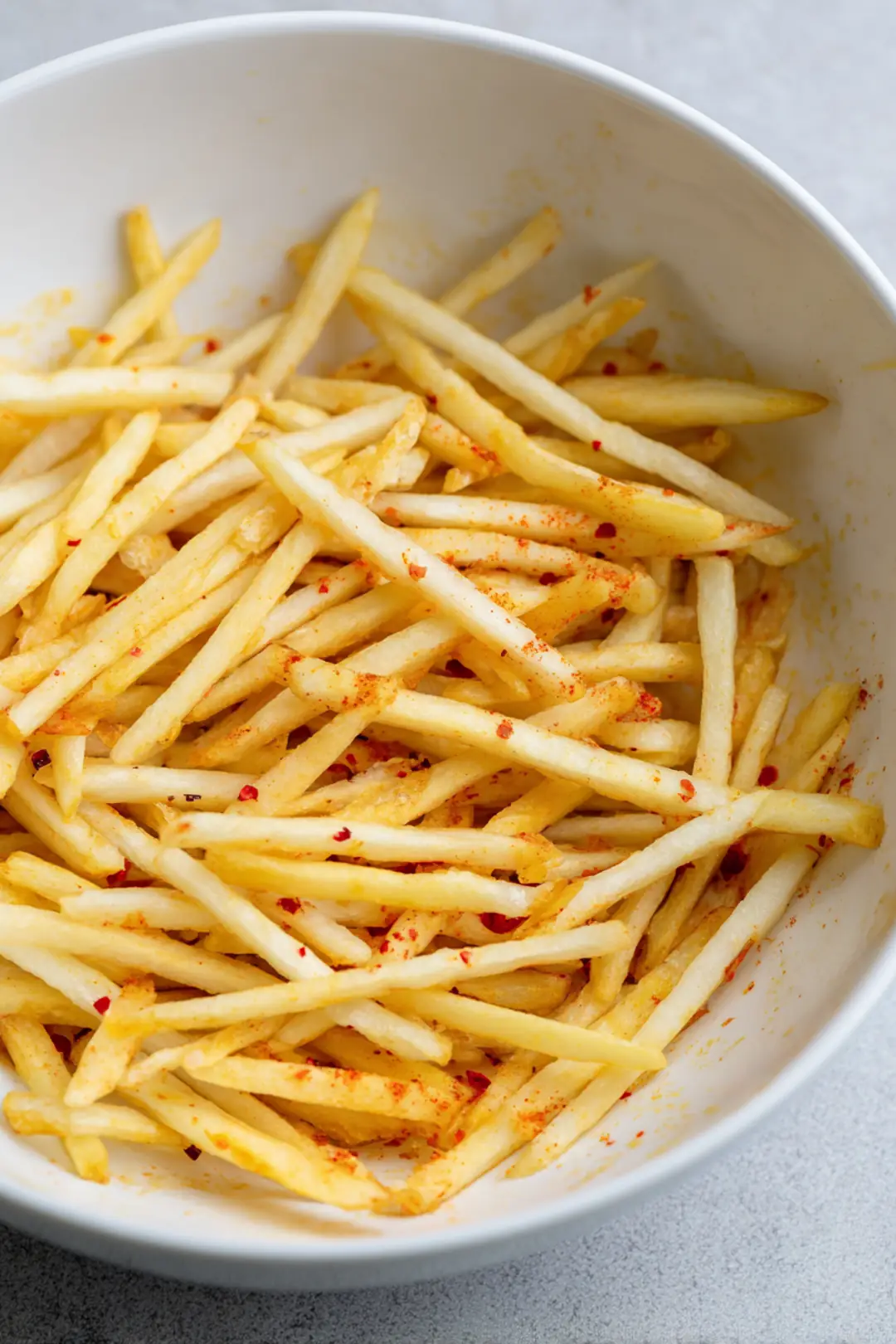 Toss the fries with vegetable oil, salt, paprika, and garlic powder