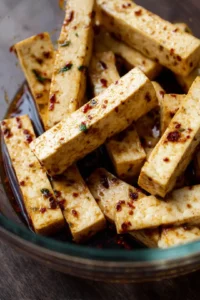 Toss the pressed tofu batons in the marinade