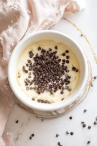 Transfer the mixture into a greased air fryer-safe dish, sprinkle chocolate chips on top if desired, and air fry for 25-30 minutes, checking for a golden, firm texture.