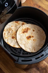 Warm the whole grain tortillas in the air fryer for 2-3 minutes to make them pliable
