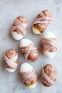 Wrap sausage patties around boiled eggs and coat in breadcrumbs