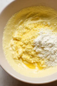 Add cornmeal, beaten egg, and mayonnaise to form batter