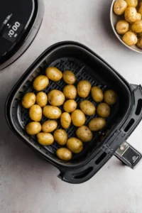 Add steak bites to air fryer with baby potatoes
