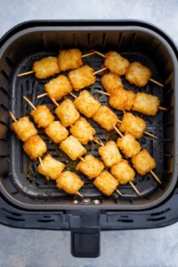 Arrange the skewers in the air fryer basket and cook for about 15 minutes until golden and crispy.