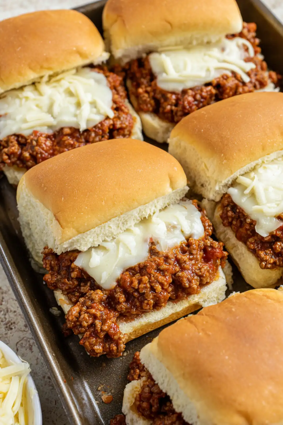 Assemble the sliders by placing some of the beef mixture on each slider roll and topping with a slice of provolone cheese. Place the sliders in the air fryer for about 10-12 minutes until the cheese is melted and bubbly.