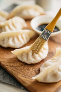 Brush oil on frozen gyoza for cooking