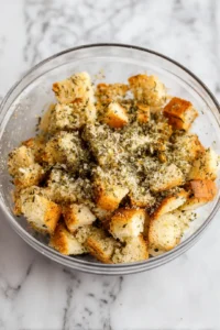 Combine bread crusts with olive oil, garlic powder, and dried herbs