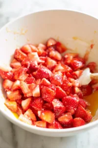 Combine chopped strawberries, eggs, honey, and coconut oil in a large bowl and mix until well combined