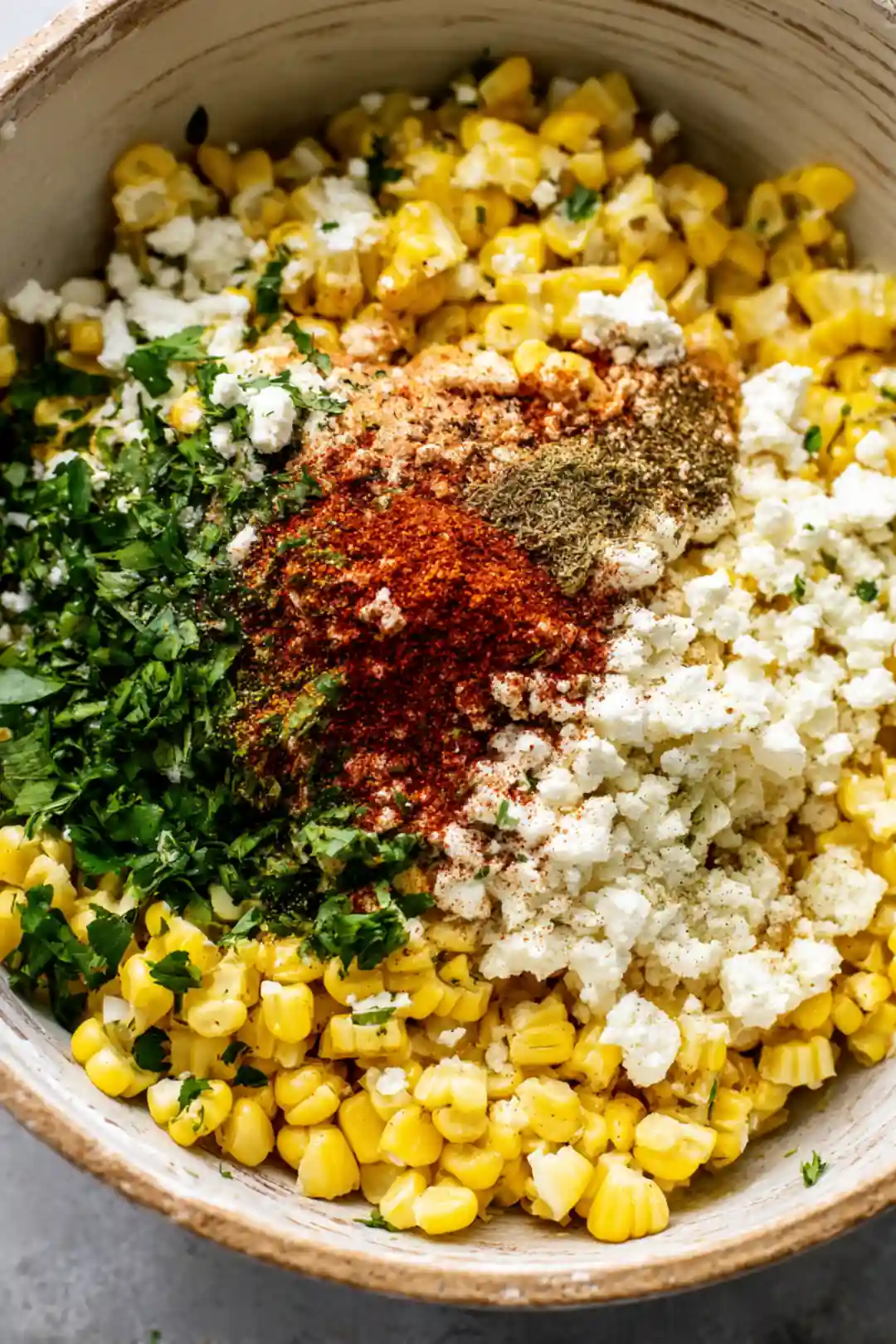Combine corn, feta, coriander, paprika, garlic powder, salt, and pepper in a bowl
