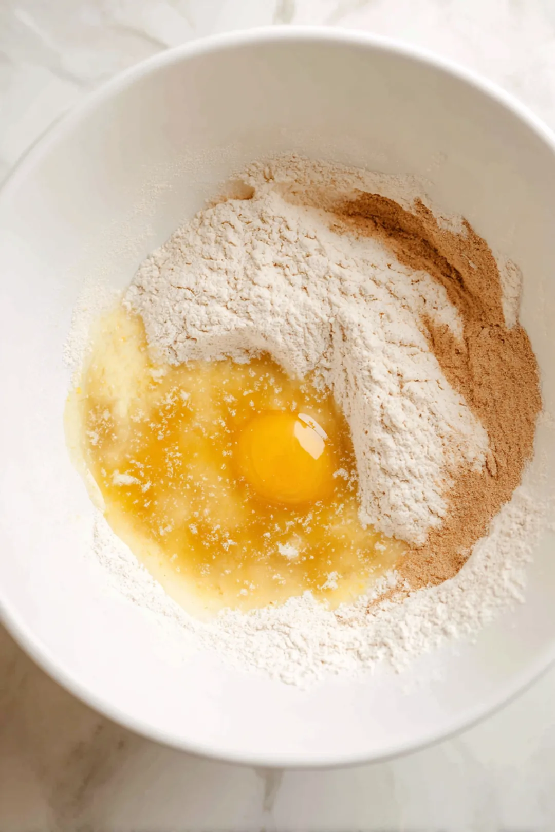 Combine flour, sugar, and cinnamon with melted butter, egg, and wine or vinegar to create a smooth dough
