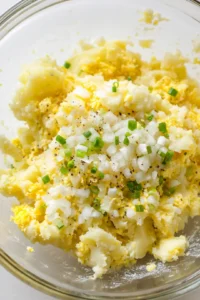 Combine grated potatoes, chopped onion, beaten egg, flour, salt, and pepper in a large bowl