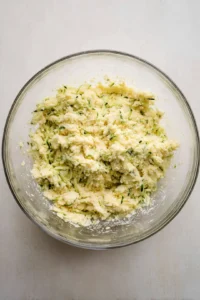 Combine grated zucchini, chickpea flour, and egg in a mixing bowl.