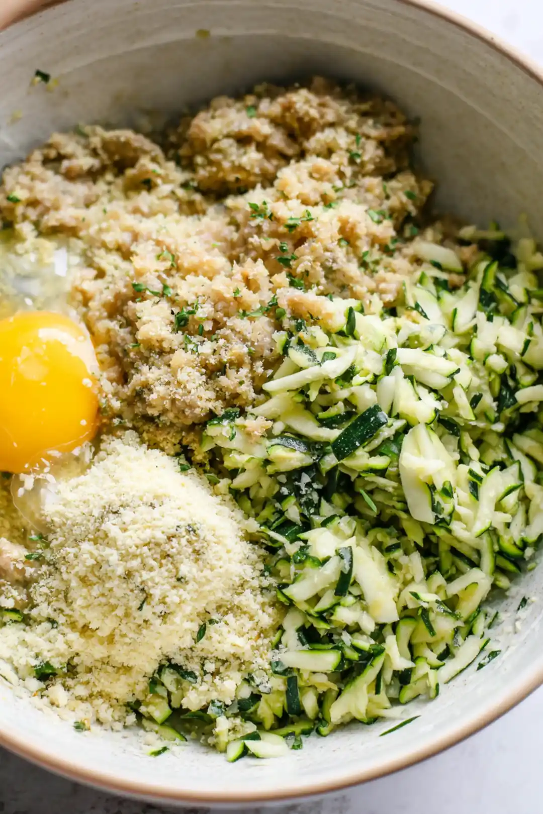 Combine ground turkey, grated zucchini, breadcrumbs, egg, minced garlic, salt, and pepper in a mixing bowl