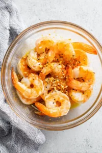 Combine melted butter, minced garlic, lemon juice, paprika, and black pepper to create the marinade for the shrimp